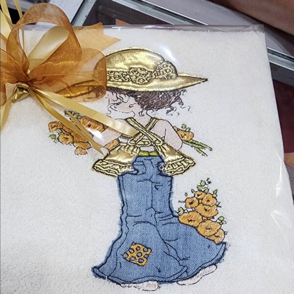 Bordado de niña con sombrero dorado, flores y lazo elegante